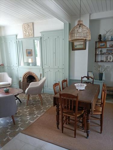 a living room with a wooden table and chairs at Le Cinquante-Trois, Maison Normande d'exception pour familles - Côte d'Albâtre in Saint-Valery-en-Caux