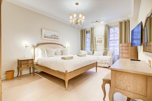 a large bedroom with a bed and a couch at London Central Residence in London