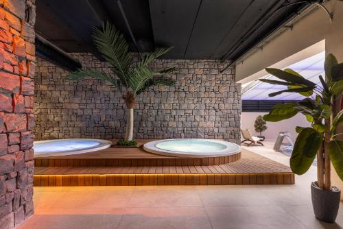 a bathroom with two large tubs with a tree in it at Kassland Resort & Spa -By Kassland Hotels in Ma'ale Adumim