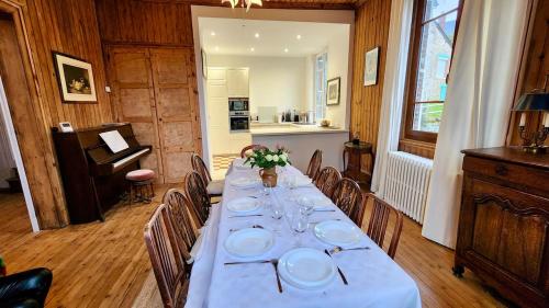 a dining room with a long table with plates on it at Villa Tournevent - Villa d'exception avec vue Mer - Veules-les-Roses in Veules-les-Roses