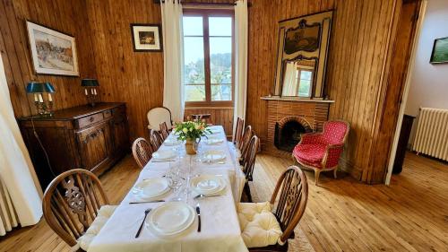 a dining room with a long table with chairs and a fireplace at Villa Tournevent - Villa d'exception avec vue Mer - Veules-les-Roses in Veules-les-Roses