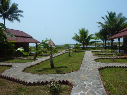 a walkway through the resort with palm trees at Java Lagoon in Pangandaran
