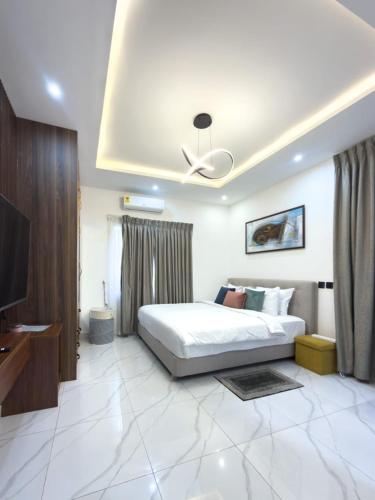 a bedroom with a bed and a flat screen tv at Luxury Double Bed Suite at THE HIDDEN DOMUS I Anomabo Suite in Accra
