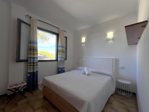 a small bedroom with a bed and a window at La Encina in Port d'Alcudia