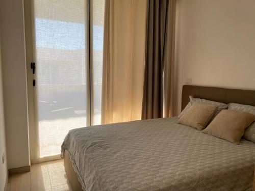 a bedroom with a bed and a large window at Apartmán Sole Vita u moře in Isca Marina