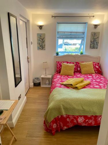 a bedroom with a bed with red sheets and yellow pillows at Boscote in Stratford-upon-Avon