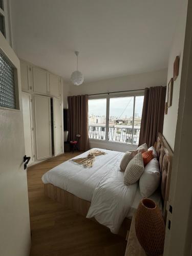 a bedroom with a large bed with a large window at Babrabat in Rabat
