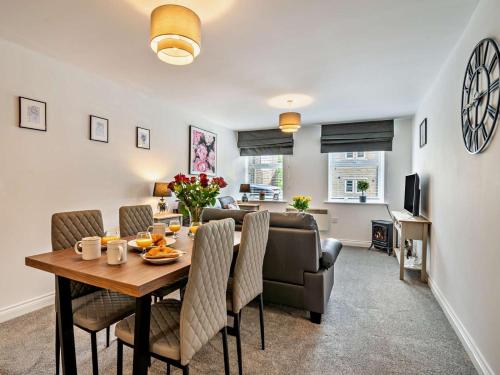 a dining room and living room with a table and chairs at 2 Bed in Holmfirth oc-95230 in Holmfirth