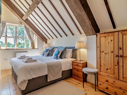 a bedroom with a large bed and a wooden ceiling at 2 Bed in Dorchester oc-92416 in Frome Vauchurch