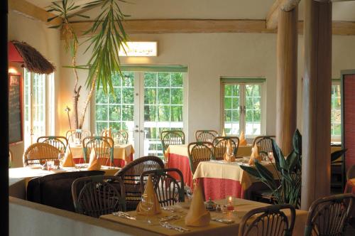 a dining room with tables and chairs and windows at Resort Hotel Corte Largo Izu Kogen in Ito