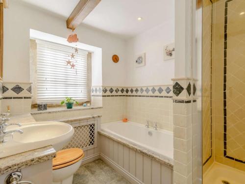 a bathroom with a tub and a sink and a toilet at 5 Bed in Harrogate oc-83663 in Summer Bridge