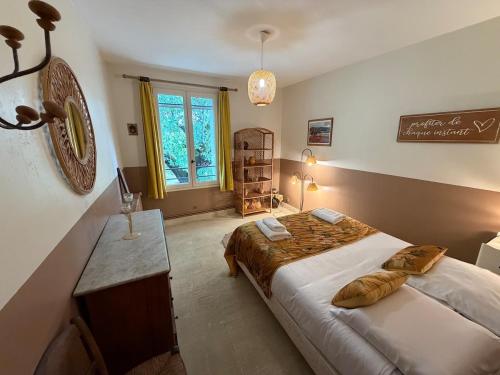 a bedroom with a bed and a table and a window at Mas de la Meï in Cavaillon