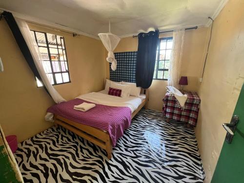 a bedroom with a bed with a zebra carpet at Mara oasis in Mara Simba