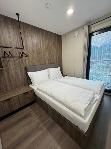 a large bed in a room with a window at CUBE Alpine Stay in Bürs