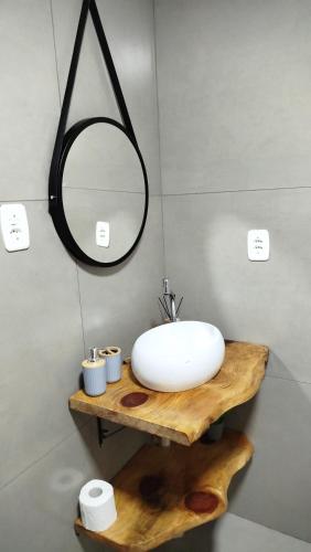a bathroom with a white sink and a mirror at Chalé Azaléia in Campo Alegre