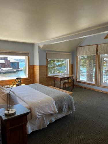 a bedroom with a large bed with a desk and windows at Casa Ayacara in Frutillar