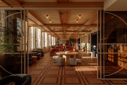a lobby with tables and chairs in a building at De Plesman Hotel The Hague in The Hague
