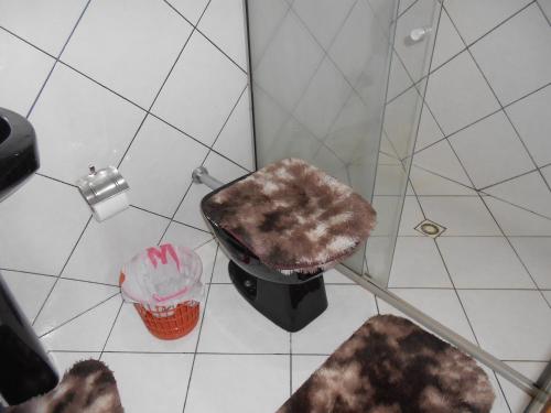 a bathroom with a shower with a trash can and a trashcan at Chacara barro branco in Foz do Iguaçu