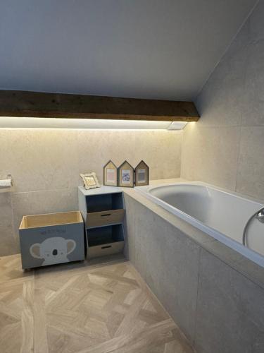 a bathroom with a tub and a box next to it at Superbe Maison 4ch proche de la mer avec piscine in Bénerville-sur-Mer