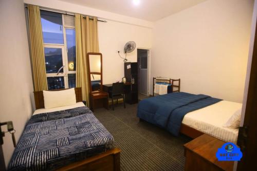 a hotel room with two beds and a window at NAT City Ella in Ella