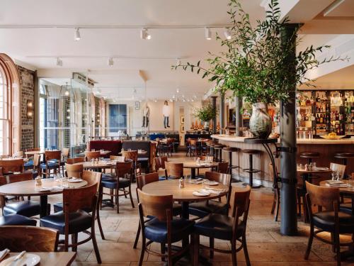 a restaurant with tables and chairs and a bar at Old Bank Hotel in Oxford