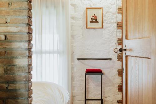 a bedroom with a red stool and a door at Il Paliarete in Orvieto