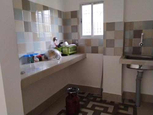 a kitchen with a sink and a counter with a shelf at Pranalay HS Warm and Cozy in Tezpur