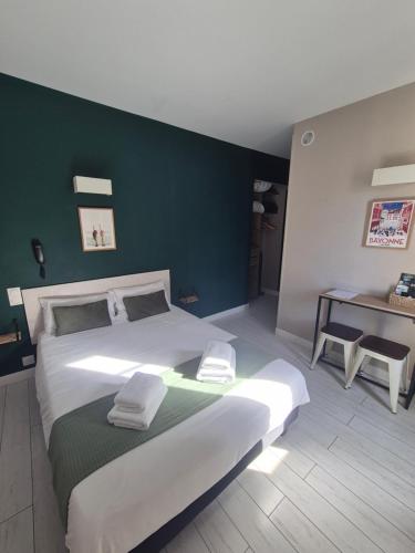 a bedroom with a large bed with a green wall at Hôtel Saint James in Biarritz