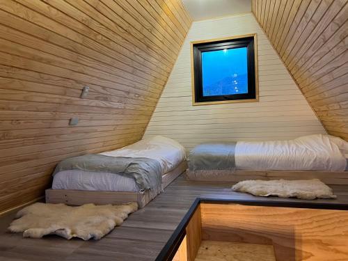 two beds in a room with a window at OUTSCAPE I Estero I Wifi I Escalada I Cerro Castillo in Villa Cerro Castillo