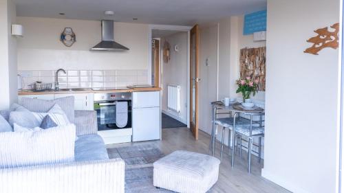 a kitchen and living room with a couch and a table at Superb Cintra Beachside Apartments in Llandudno