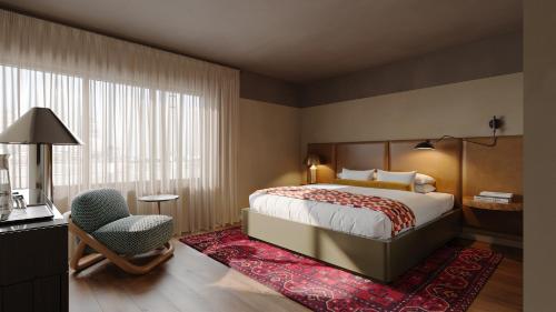 a bedroom with a bed and a desk and a chair at All Inn Hotel in Denver