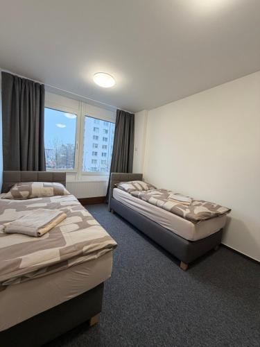 a bedroom with two beds and a window at Penzion BETA in Třebíč