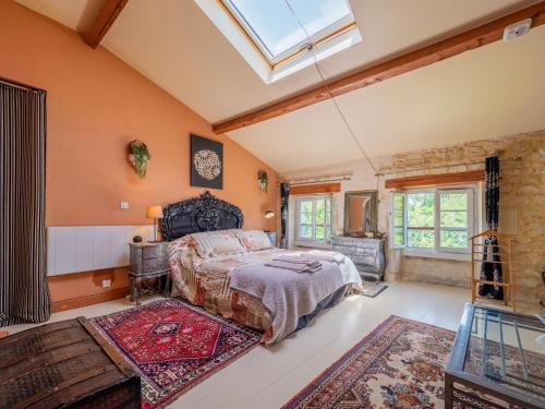 a bedroom with a large bed and a skylight at Beautiful large stylish villa centrally located in Pons in Pons