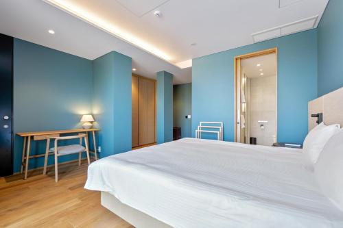 a bedroom with a large white bed and blue walls at Villa Mori - Odin Hills in Kutchan