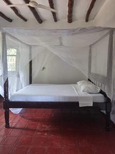a bed with a canopy in a room at Sofia House - Beach Paradise with Kite, Dive and more in Watamu