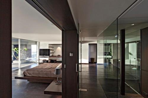 Duplex Desing Lyonnais في Saint-Didier-au-Mont-dʼOr: غرفة نوم بها سرير وجدار زجاجي