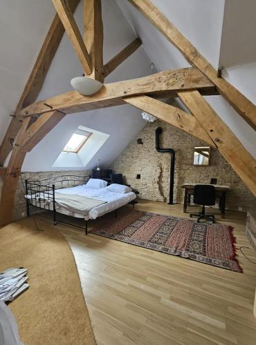 a loft bedroom with a bed and a desk at Sweet Pea Cottage in Donzy