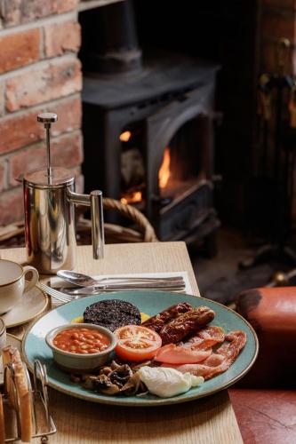 a plate of food on a table in front of a fireplace at The Sunningdale in Bamburgh