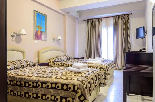 a hotel room with two beds and a piano at Hotel Athina in Kato Loutraki