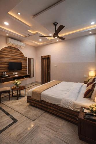 a bedroom with a large bed and a flat screen tv at Hotel Crown Patliputra in Patna