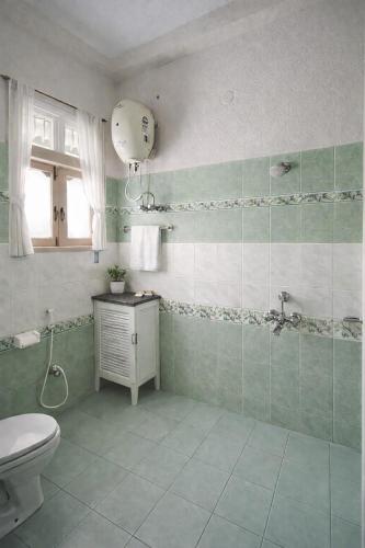 a bathroom with a toilet and a sink at Hotel Crown Patliputra in Patna