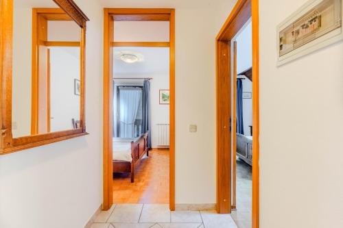 a hallway with a mirror and a room with a bed at Apartments Mija in Krotica