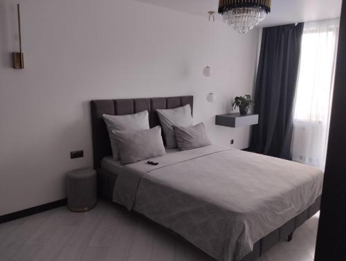a bedroom with a large bed with white sheets and pillows at Balka-centr Tiraspol in Tiraspol