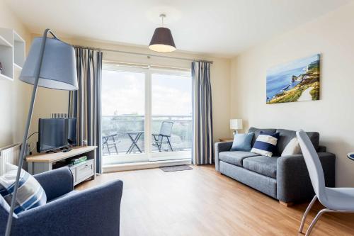 a living room with a couch and a tv at Coxswain's Cabin - Moments from Hamworthy Beach and Park in Poole