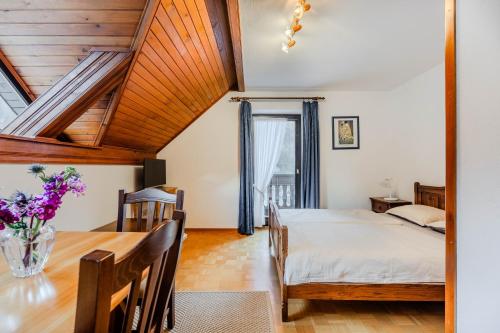 a dining room with a table and a bed at Apartments Mija in Krotica