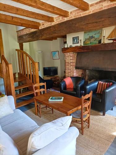 a living room with a couch and a table at Gîte rural de Criquemanville - Maison familial 4 chambre avec grand jardin in Sassetot-le-Mauconduit