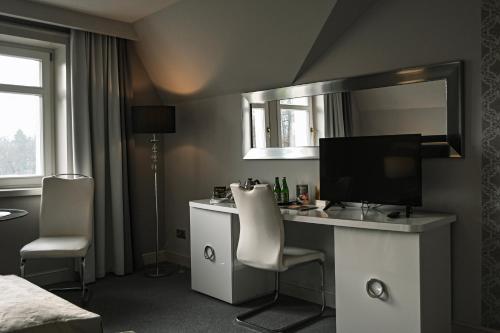 a bedroom with a desk with a computer and a mirror at Pałac Brzeźno Spa & Golf in Oborniki Śląskie