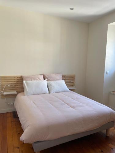 a bedroom with a large bed with white sheets and pillows at Maison de ville in Lannion