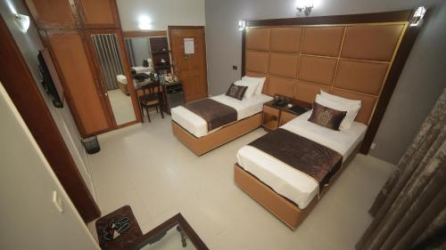 a hotel room with two beds and a kitchen at Four Squares by WIH in Karachi