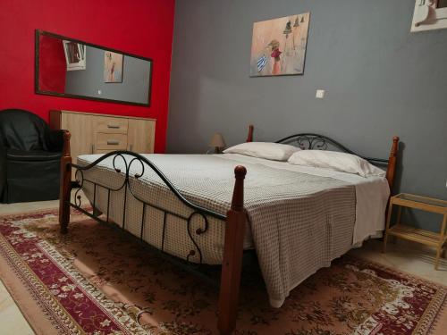 a bedroom with a bed and a red wall at Magda's apartments in Perea